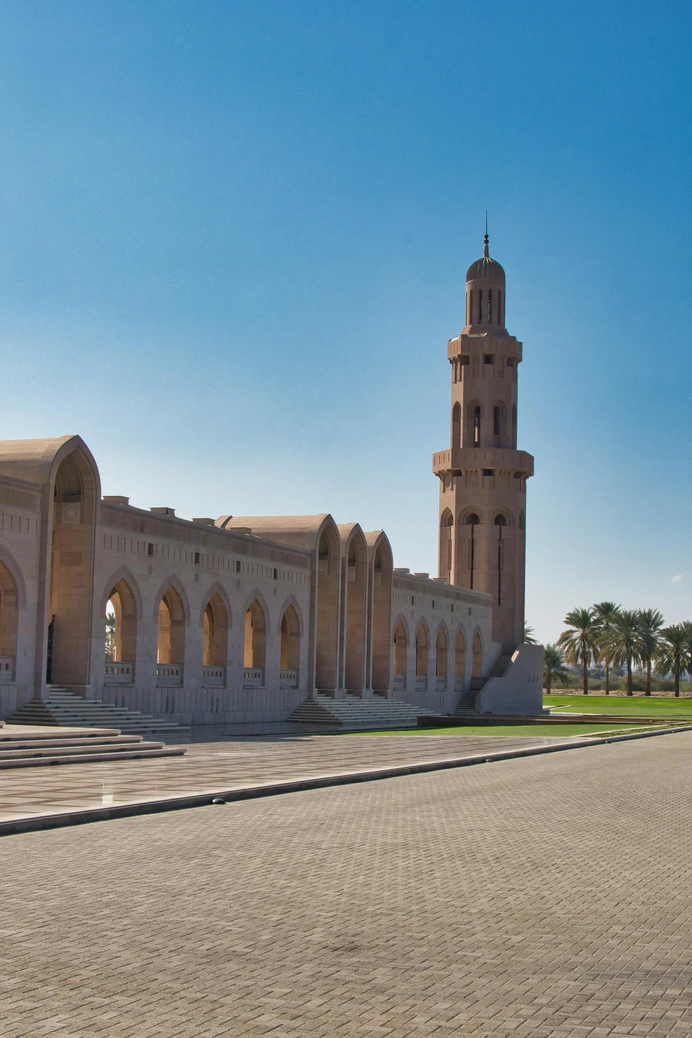 Grand mosque and minaret in Muscat under clear sky — Oman institutional architecture